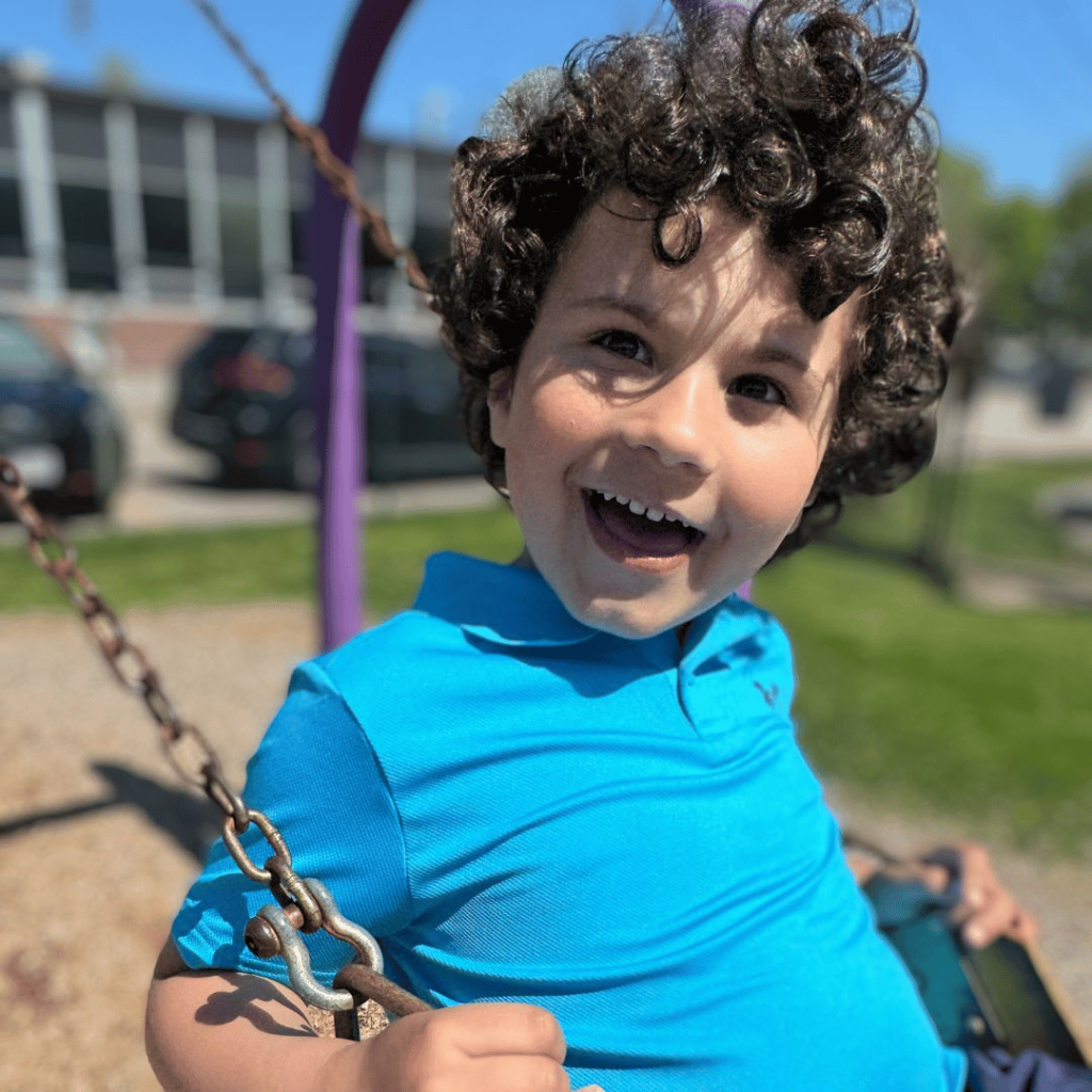 RCS preschool ABA therapy student swinging on playground